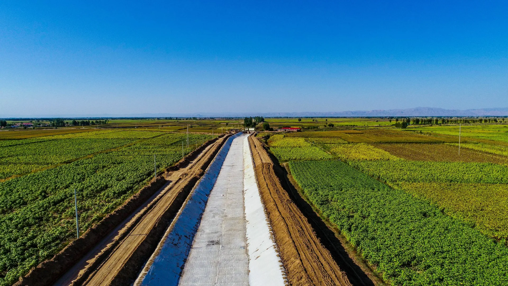 Canal lining through farmland aerial view