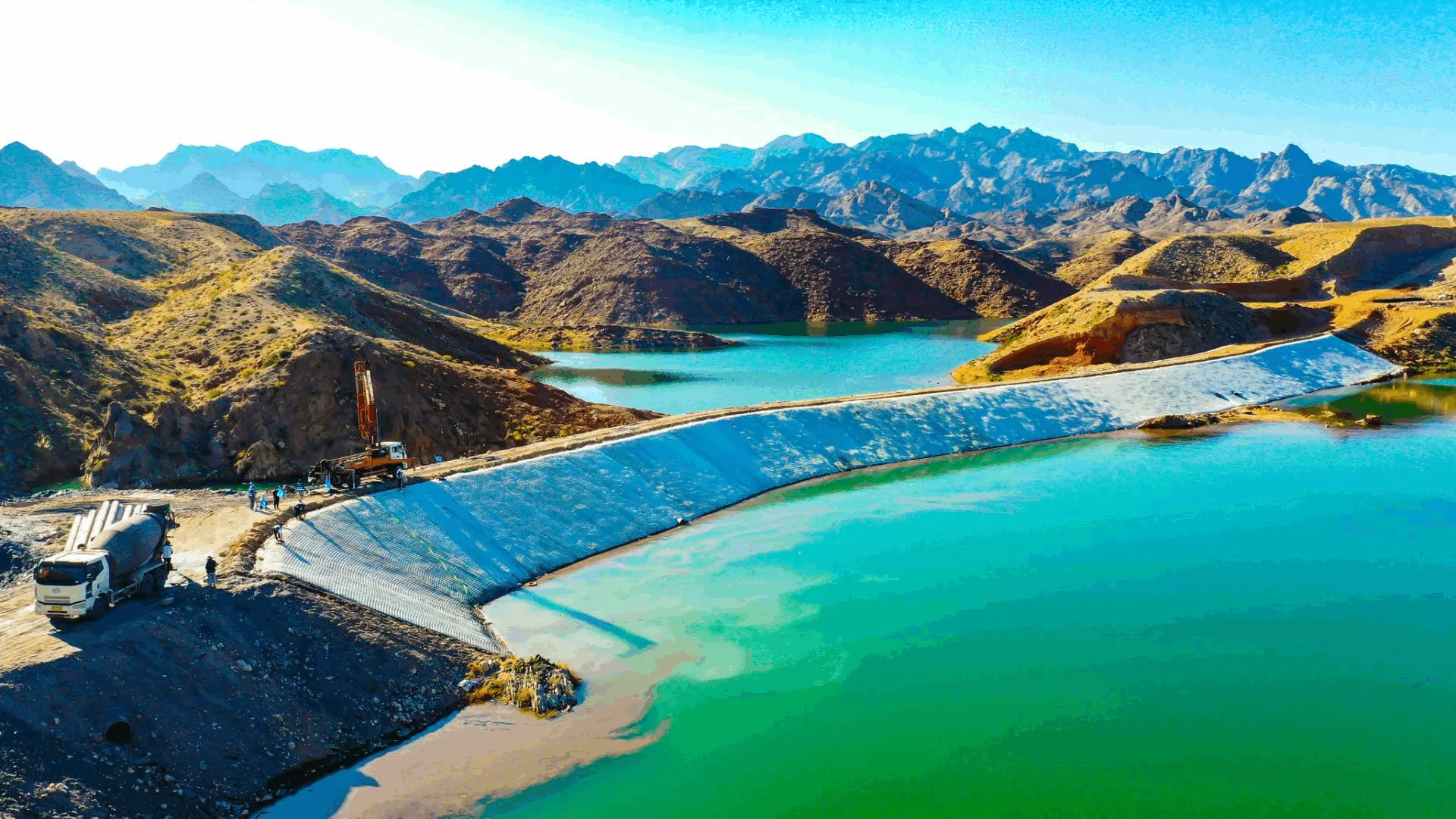Mountain reservoir with grouted mattress dam face